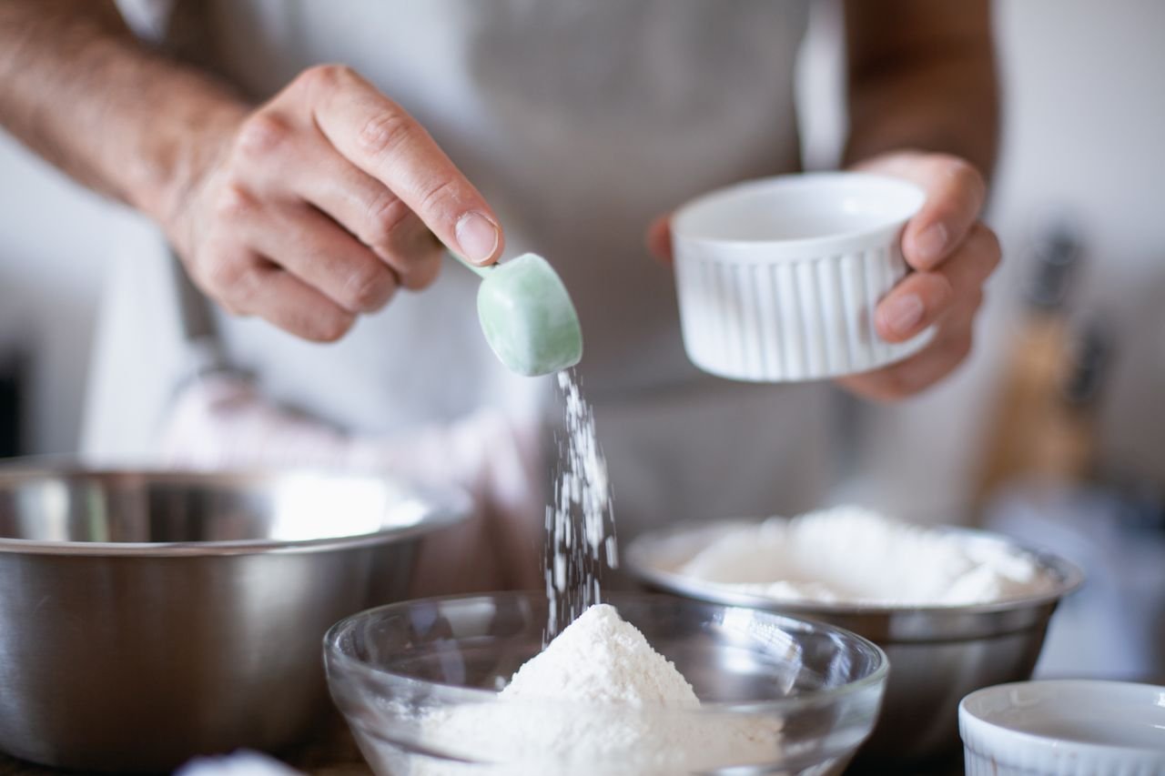 Crafting Captivating Headlines: Your awesome post title goes here Close-up of hands measuring ingredients in a kitchen for baking.